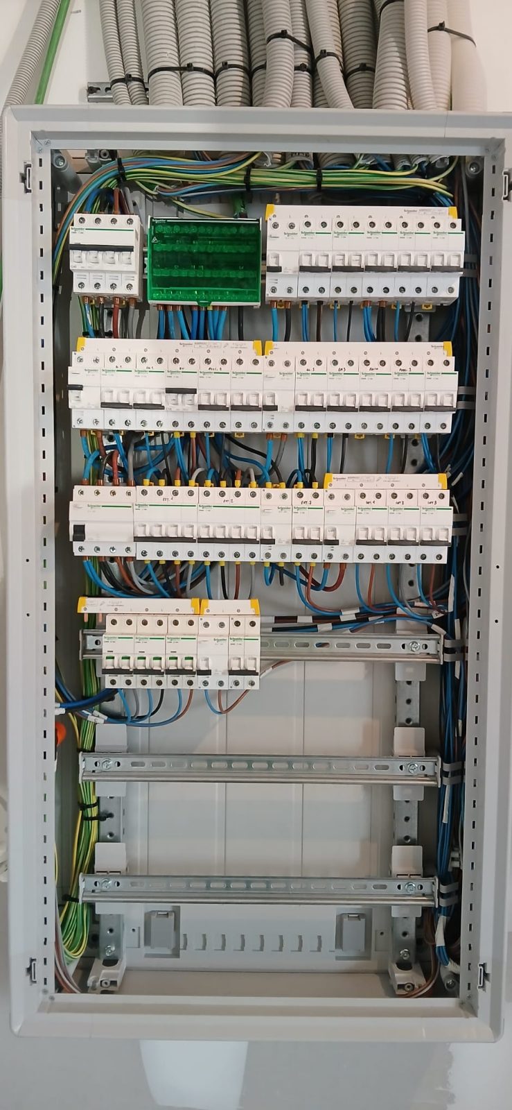 Cuadro eléctrico Schneider con los circuitos rotulados y los tubos de la instalación entrando por arriba