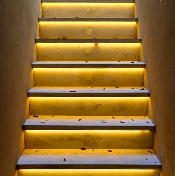 Escalera con iluminación LED cálida integrada bajo cada peldaño