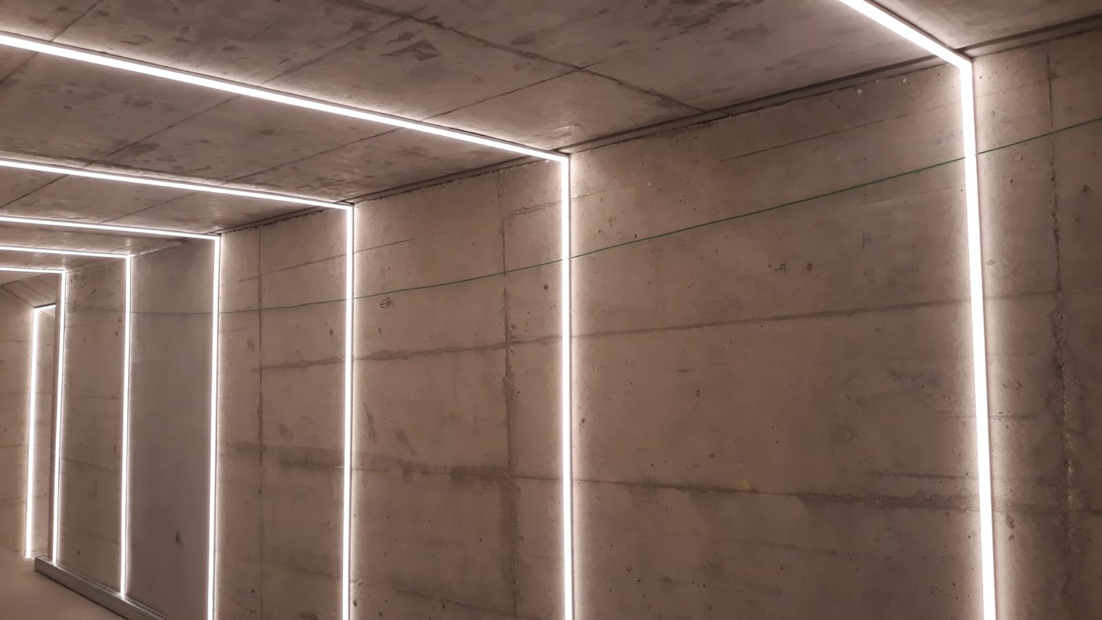 Pasillo de hormigón con líneas continuas de iluminación LED